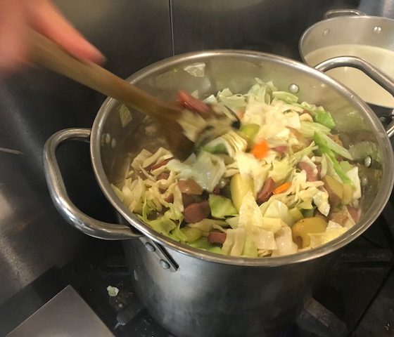 feed the community adding cabbage to the soup