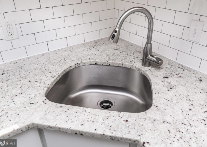 3039 Fleetwood Avenue, kitchen sink with countertops and tile wall