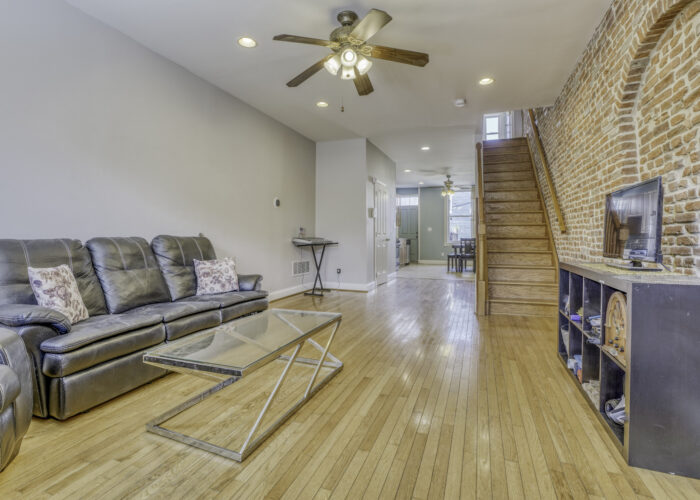 3304 E Baltimore St., living room with ceiling fan and exposed brick