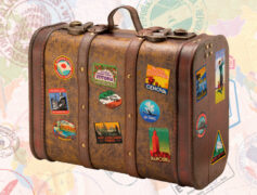 Suitcase with stickers from cities around the world on a background of passport stamps from all over.