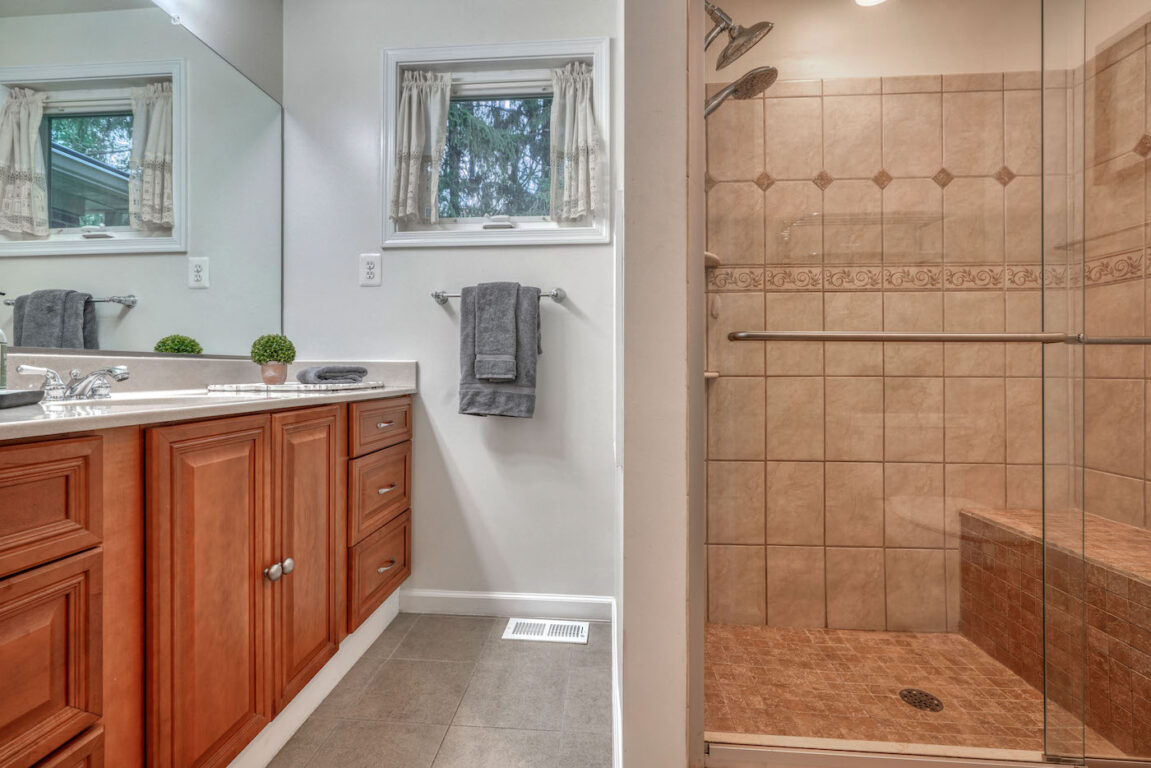 31 Millstone Road, primary bathroom has lots of storage and seat in shower.
