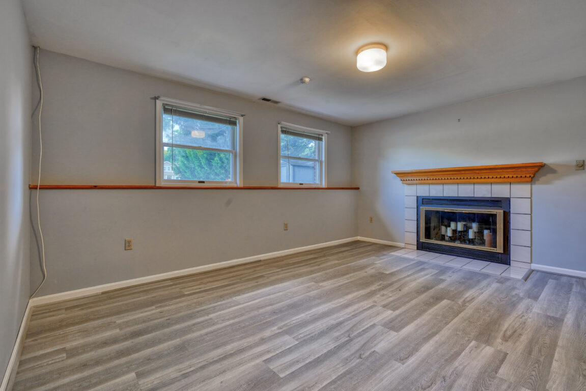 7512 Riddle Avenue, lower level family room with windows, fireplace and ceiling light fixture.