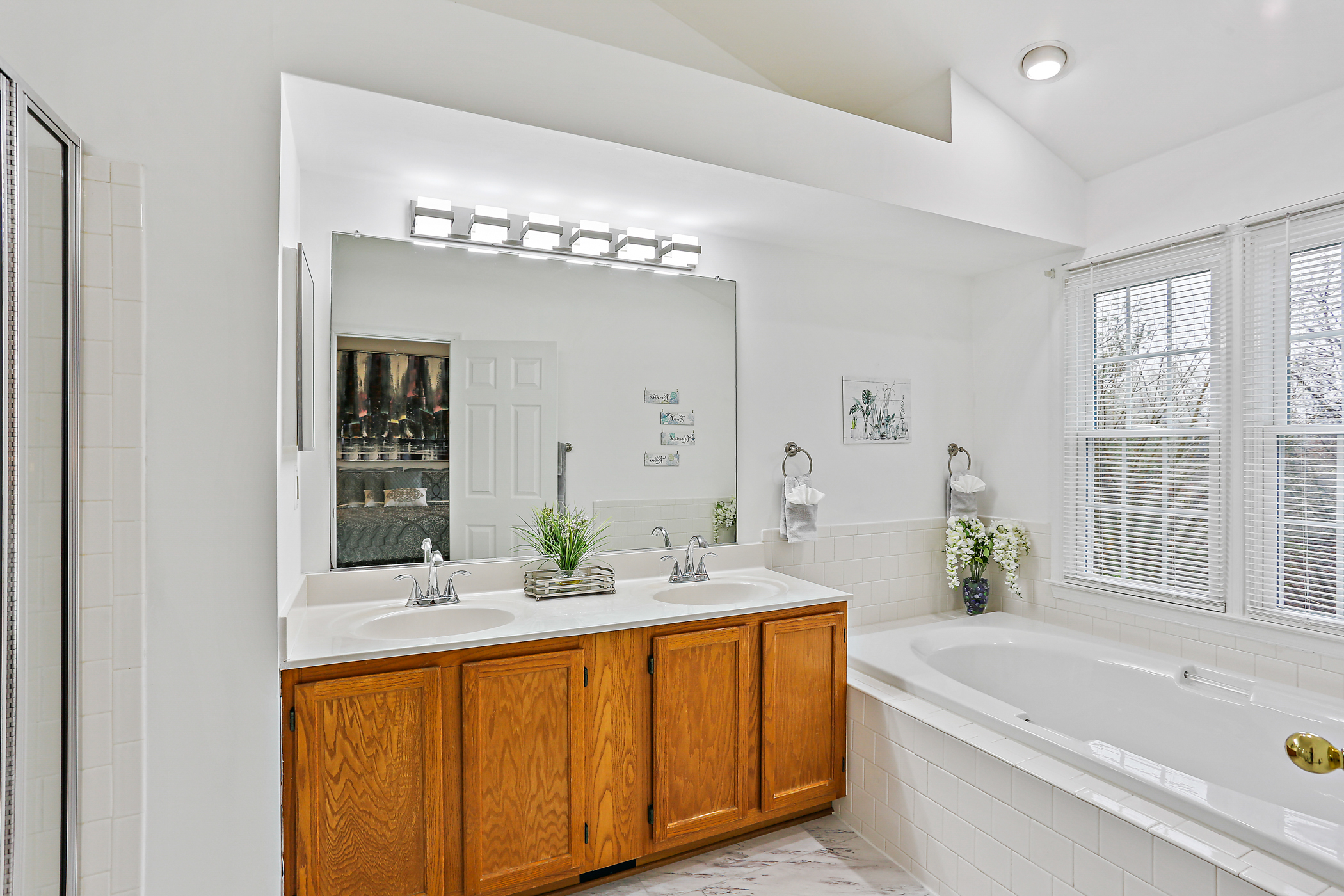6203 Knolls Ct, double vanity in bathroom with sunken tub and glass shower.